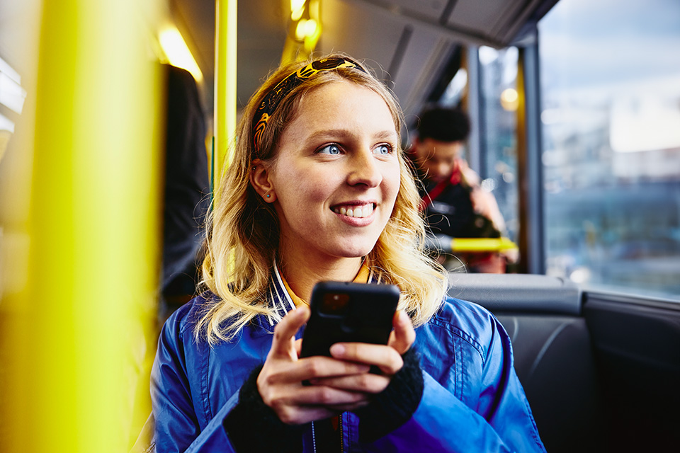 ragazza sull'autobus che guarda il telefono