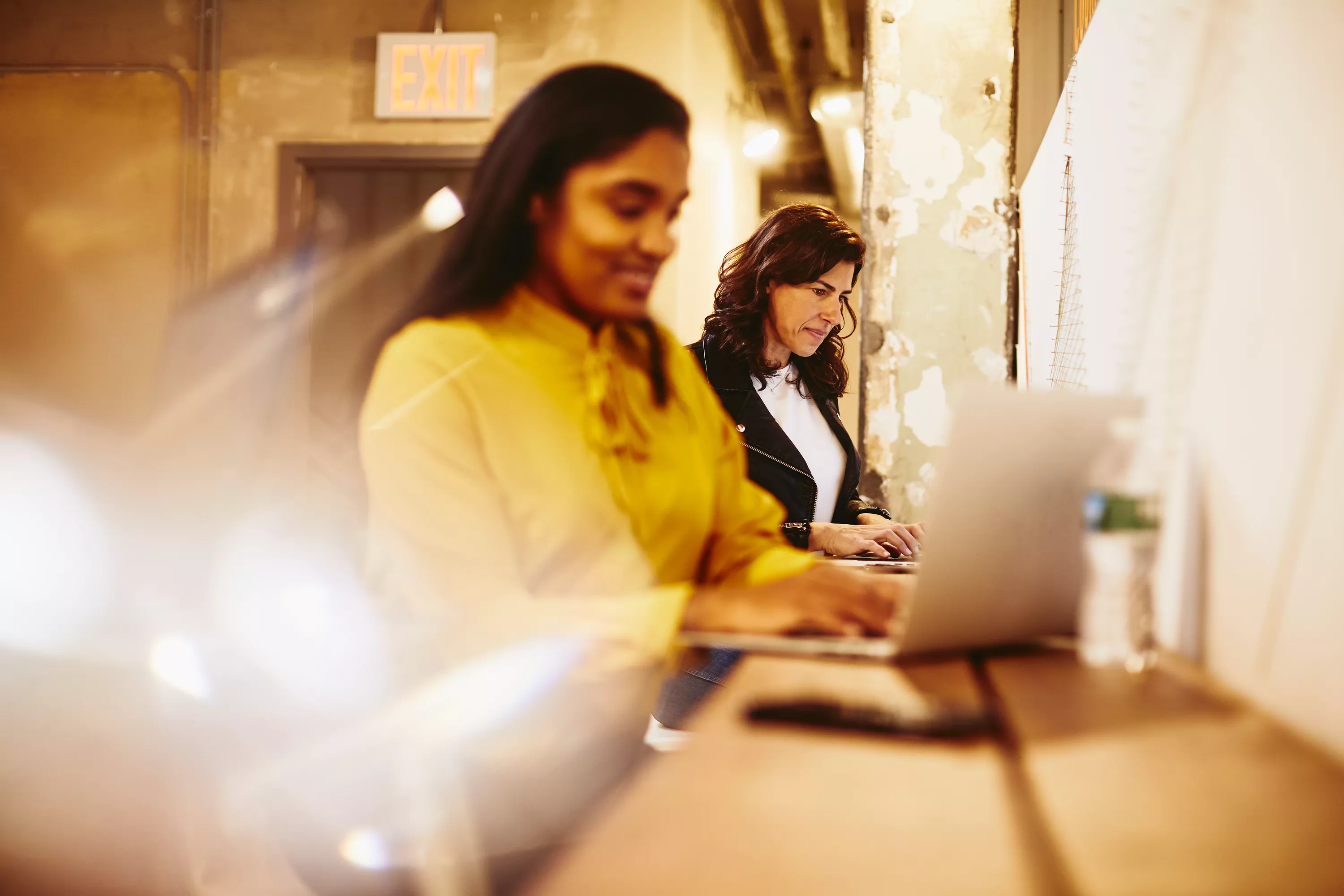 due donne che lavorano al pc sedute ad un bancone